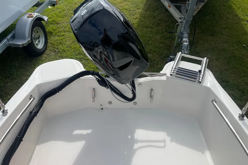 Slide: The Image of 2026 Boston Whaler 130 Super Sport boat with motor and ladder, viewed from above. - 13