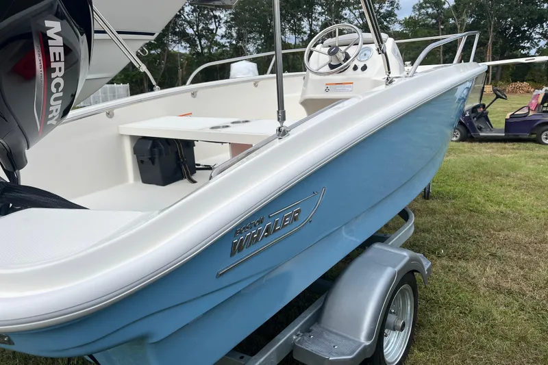 Slide: The Image of 2026 Boston Whaler 130 Super Sport boat on trailer, featuring Mercury engine. - 14