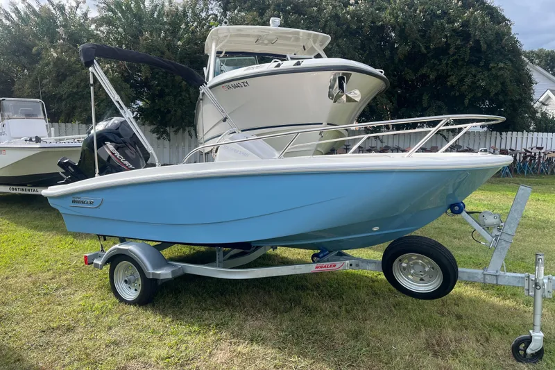 Slide: The Image of 2026 Boston Whaler 130 Super Sport boat on trailer, displayed outdoors. - 15