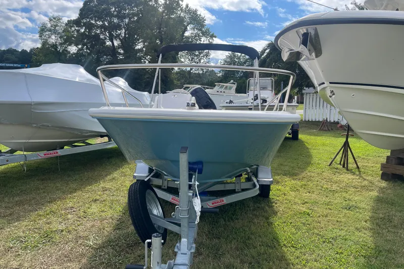 Slide: The Image of 2026 Boston Whaler 130 Super Sport boat on trailer, parked on grass. - 16
