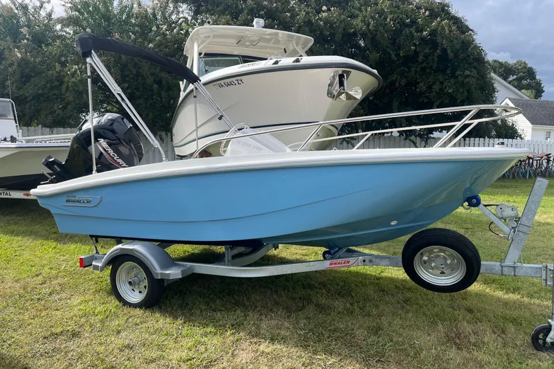 Slide: The Image of 2026 Boston Whaler 130 Super Sport boat on trailer, displayed outdoors. - 19