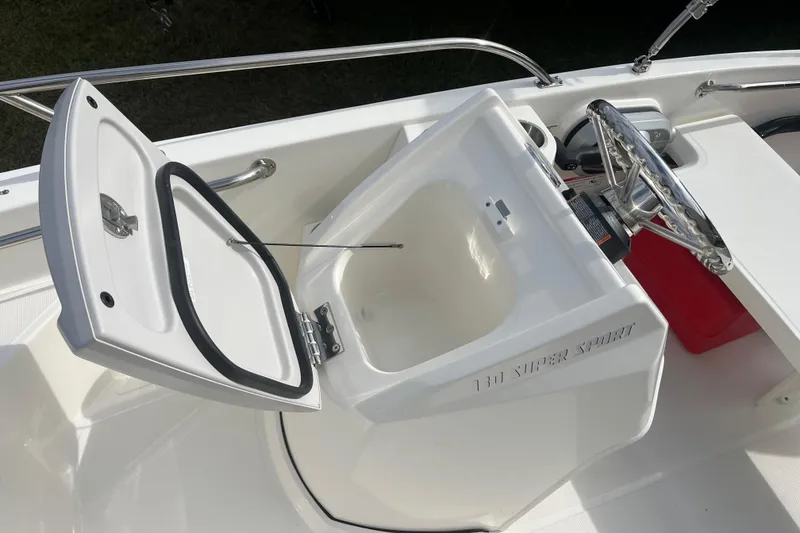 Slide: The Image of 2026 Boston Whaler 130 Super Sport boat console with open storage compartment. - 8
