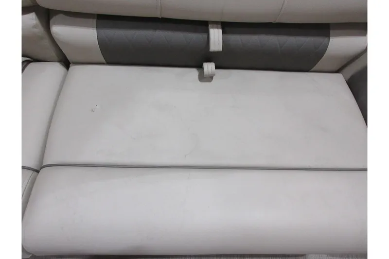 Slide: The Image of 2024 Sun Tracker Party Barge 24 DLX seating, featuring gray and white cushioned upholstery. - 12