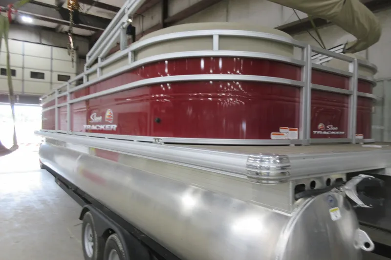 Slide: The Image of 2024 Sun Tracker Party Barge 24 DLX pontoon boat in a warehouse setting. - 4