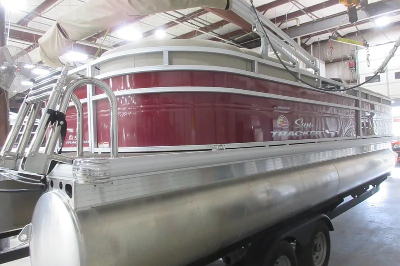 Slide: The Image of 2024 Sun Tracker Party Barge 24 DLX pontoon boat in a warehouse setting. - 5
