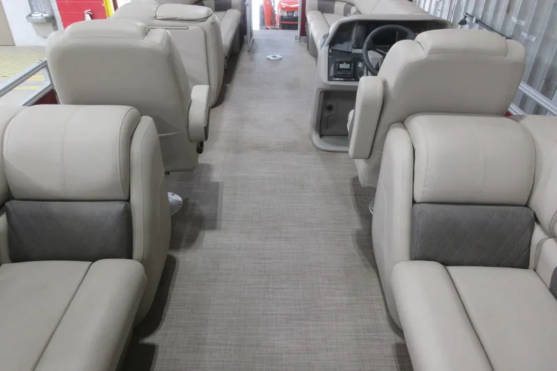 Slide: The Image of 2024 Sun Tracker Party Barge 24 DLX interior with beige seating and steering console. - 7