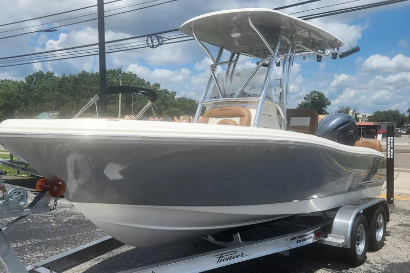 The Image of 2026 Pioneer 202 Sportfish boat on trailer, sleek design, under clear blue sky. - 1