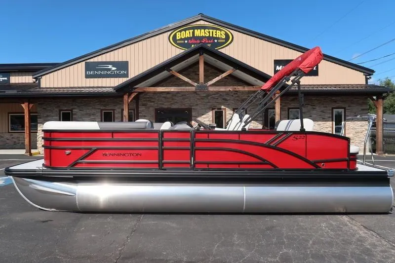 Slide: The Image of 2026 Bennington S Swingback 22 SSB SPS pontoon boat in vibrant red, parked outside dealership. - 7