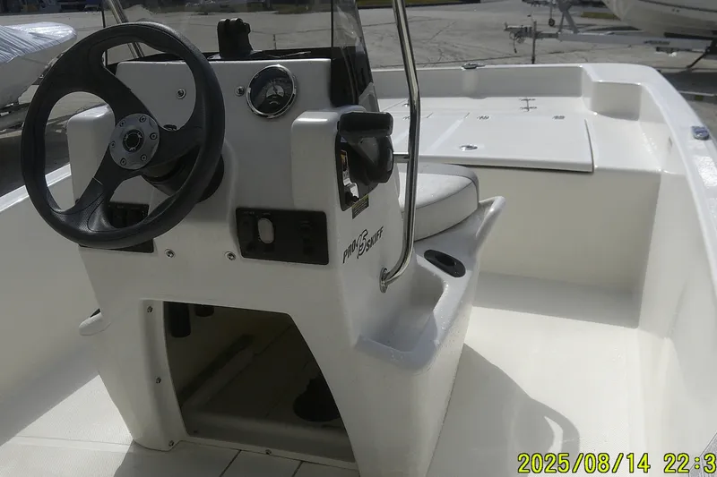 Slide: The Image of 2024 Mako Pro Skiff 15 CC boat interior with steering console and seating. - 16