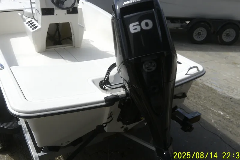 Slide: The Image of 2024 Mako Pro Skiff 15 CC with 60 HP Mercury outboard engine on trailer. - 18