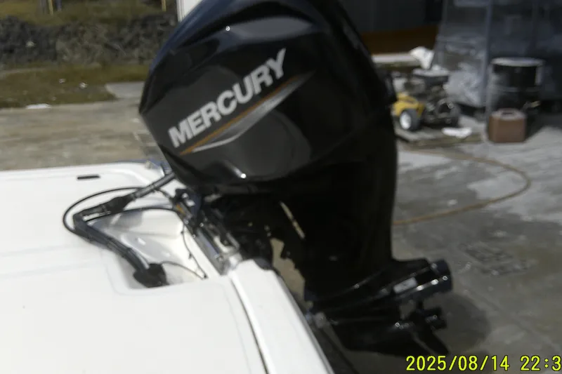 Slide: The Image of 2024 Mako Pro Skiff 15 CC with Mercury outboard motor, docked outdoors. - 19
