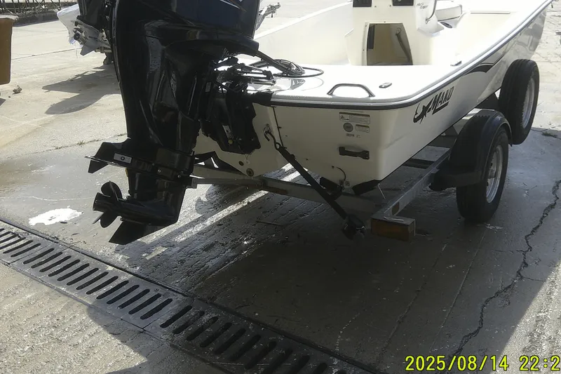 Slide: The Image of 2024 Mako Pro Skiff 15 CC on trailer, rear view with outboard motor. - 2