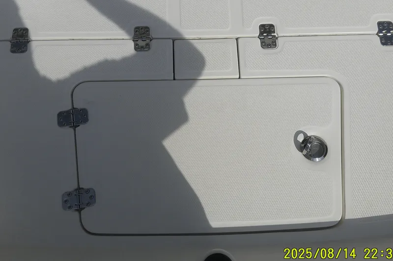 Slide: The Image of 2024 Mako Pro Skiff 15 CC deck with storage hatch and metal hinges. - 8