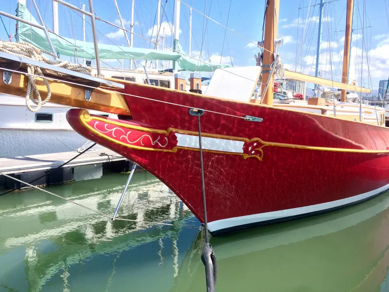 The Image of Red 1971 Formosa 41 sailboat docked in marina, featuring ornate detailing and wooden mast. - 0