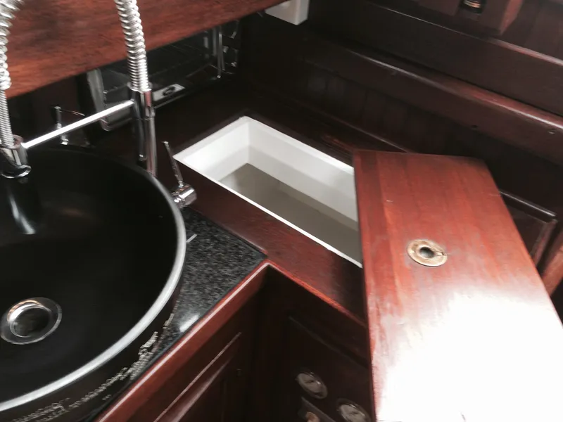 Slide: The Image of Interior of a 1971 Formosa 41 yacht with wooden cabinetry and a black sink. - 10