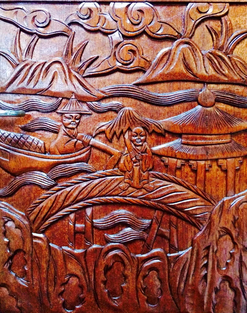 Slide: The Image of Intricately carved wooden panel depicting traditional Asian scenery, featuring mountains and figures in a boat. - 23