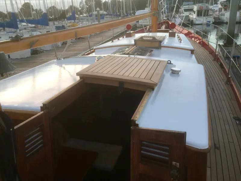 Slide: The Image of 1971 Formosa 41 sailboat deck with wooden hatch and marina background. - 32