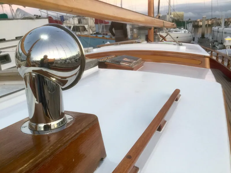 Slide: The Image of 1971 Formosa 41 yacht deck with polished metal and wooden details in a marina setting. - 37