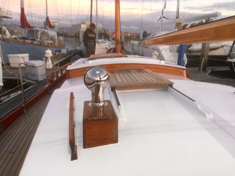 Slide: The Image of 1971 Formosa 41 sailboat deck with wooden details at sunset in a marina. - 41
