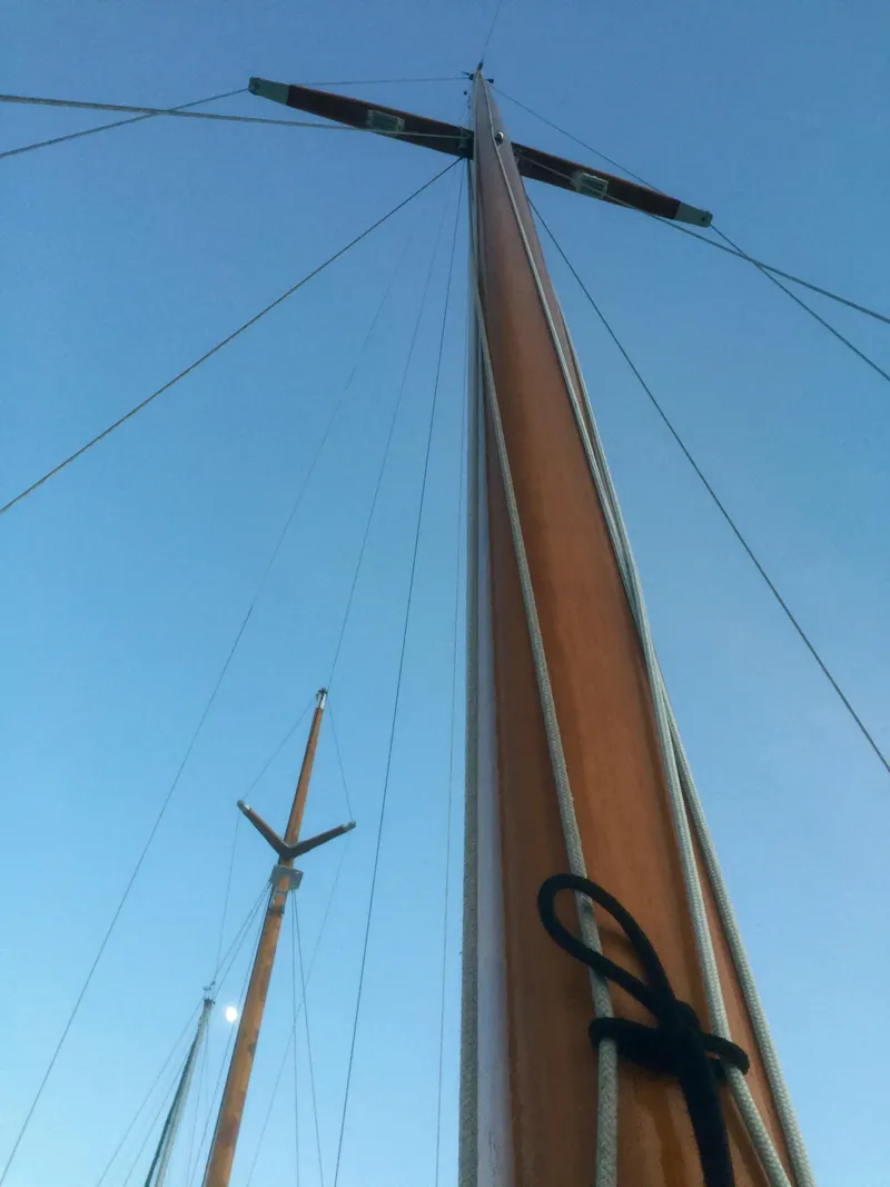 Slide: The Image of Tall wooden masts of a 1971 Formosa 41 sailboat against a clear blue sky. - 46