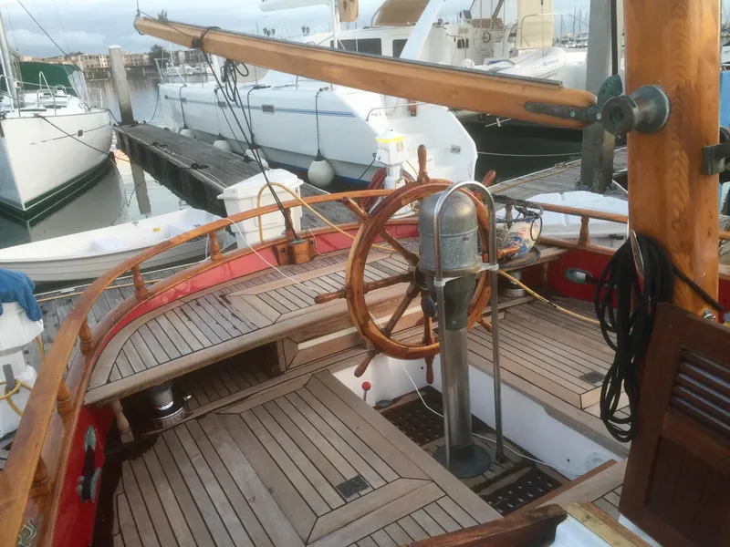 Slide: The Image of 1971 Formosa 41 sailboat with wooden deck and steering wheel, docked at a marina. - 51