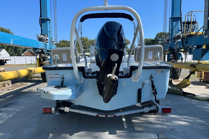 Slide: The Image of 2026 Boston Whaler 170 Montauk boat on trailer, rear view, in a marina setting. - 20