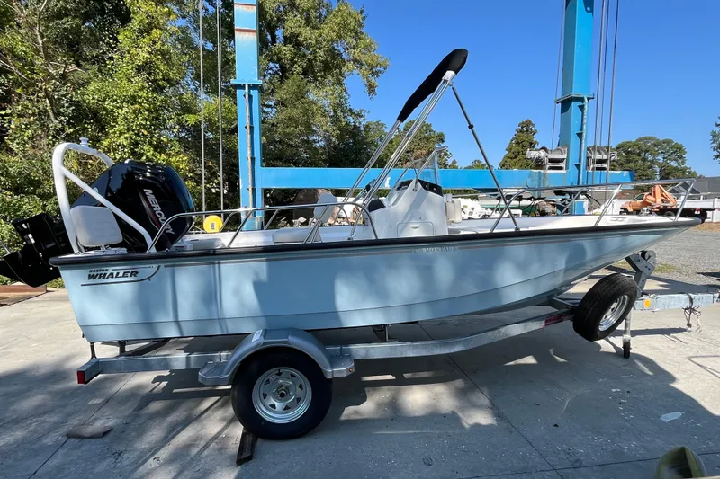Slide: The Image of 2026 Boston Whaler 170 Montauk boat on trailer, outdoors under blue sky. - 23