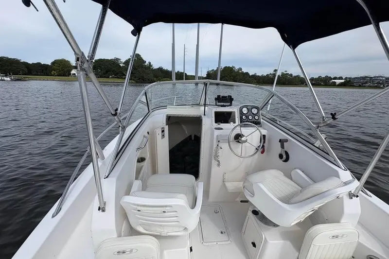 Slide: The Image of 2007 Seahunt VICTORY 225 boat interior with steering wheel and seating on calm water. - 10