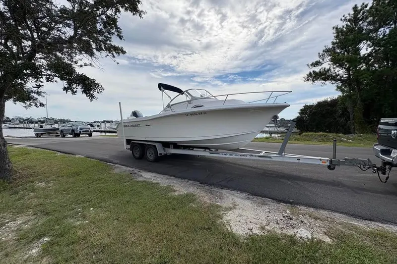 Slide: The Image of 2007 Seahunt VICTORY 225 boat on trailer near marina, under cloudy sky. - 4