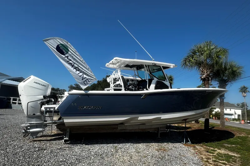 The Image of 2025 Blackfin 332 CC boat displayed outdoors with Mercury engine, under clear blue sky. - 0