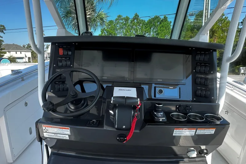 Slide: The Image of 2025 Blackfin 332 CC boat dashboard with steering wheel, controls, and navigation screens. - 5