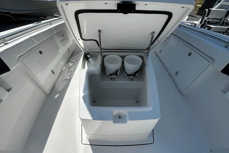 Slide: The Image of 2025 Blackfin 332 CC boat storage compartment with open lid and two white buckets. - 8