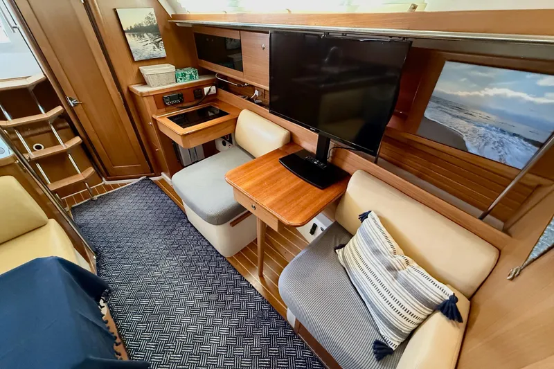 Slide: The Image of Interior of a 2011 Catalina 355 yacht with cozy seating and a mounted TV. - 25