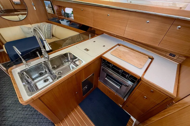 Slide: The Image of Luxurious 2011 Catalina 355 yacht kitchen with dual sinks, stove, and wooden cabinetry. - 28