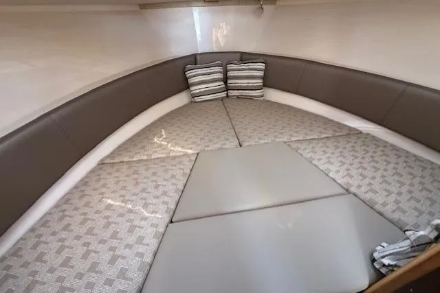 Slide: The Image of 2024 Cutwater C-288 Coupe interior cabin with cushioned seating and striped pillows. - 10