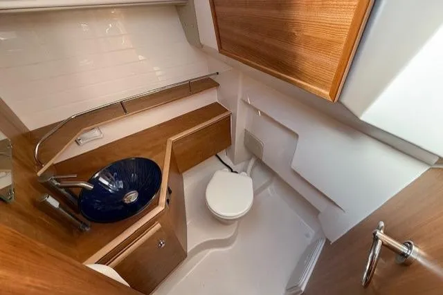 Slide: The Image of 2024 Cutwater C-288 Coupe bathroom with modern sink, wooden cabinetry, and compact toilet. - 13