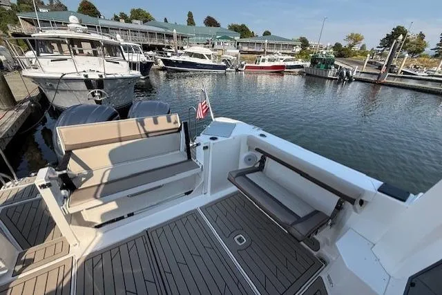 Slide: The Image of 2024 Cutwater C-288 Coupe at marina, featuring spacious deck and seating area. - 5