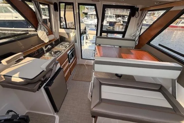 Slide: The Image of 2024 Cutwater C-288 Coupe interior with kitchen and seating area, docked at marina. - 8