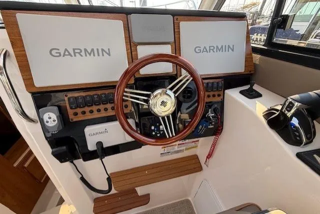 Slide: The Image of 2024 Cutwater C-288 Coupe helm with Garmin displays and wooden steering wheel. - 9