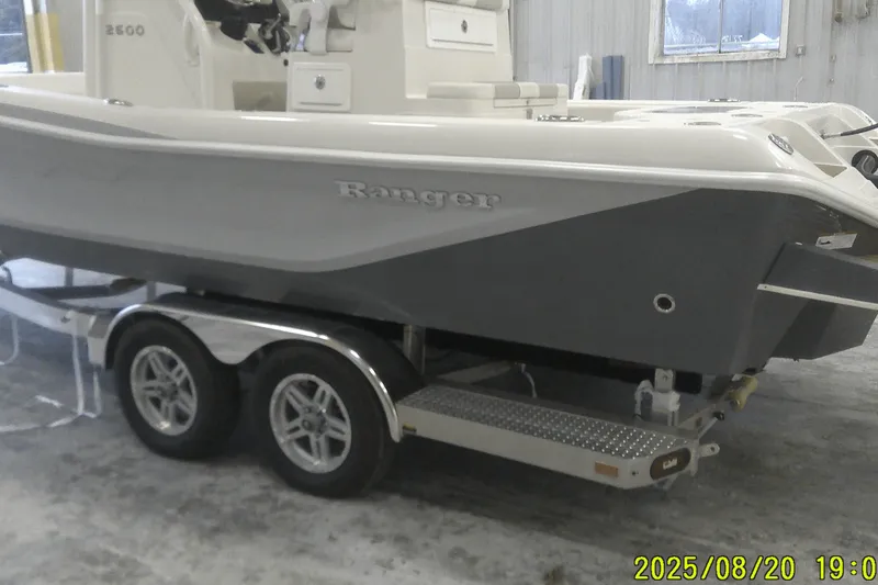 Slide: The Image of 2024 Ranger 2600 Bay boat on a trailer in a garage setting. - 0