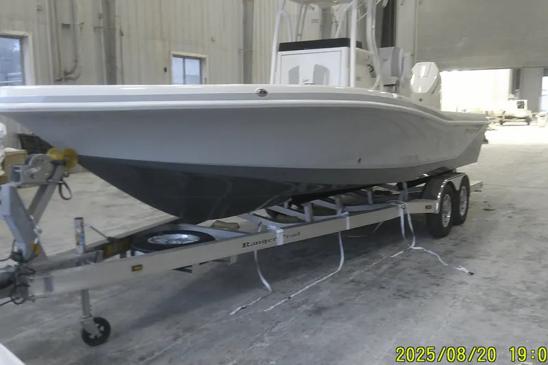 Slide: The Image of 2024 Ranger 2600 Bay boat on trailer in warehouse setting. - 1