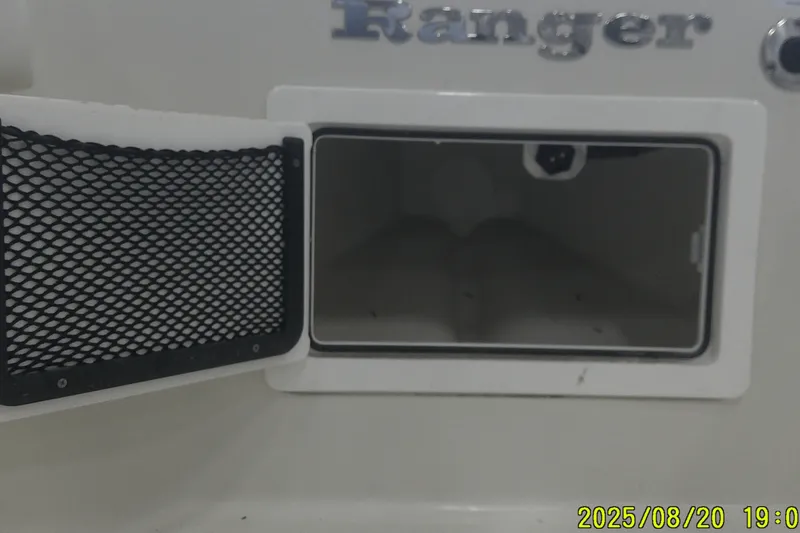Slide: The Image of Open storage compartment on 2024 Ranger 2600 Bay boat, featuring mesh pocket and sleek design. - 15