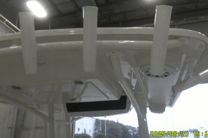 Slide: The Image of 2024 Ranger 2600 Bay boat interior, featuring rod holders and overhead lighting in a warehouse setting. - 30