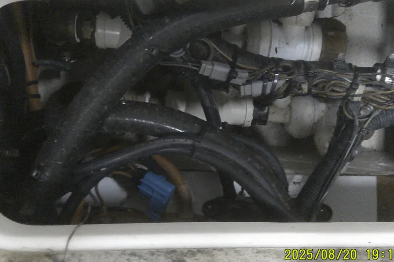 Slide: The Image of Engine compartment of a 2024 Ranger 2600 Bay boat with visible wiring and hoses. - 49
