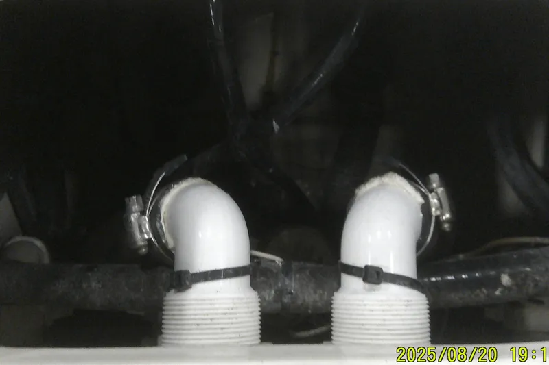 Slide: The Image of Plumbing components inside a 2024 Ranger 2600 Bay boat, featuring pipes and clamps. - 52