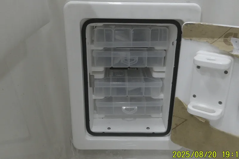 Slide: The Image of Storage compartment with clear plastic trays in a 2024 Ranger 2600 Bay boat. - 54