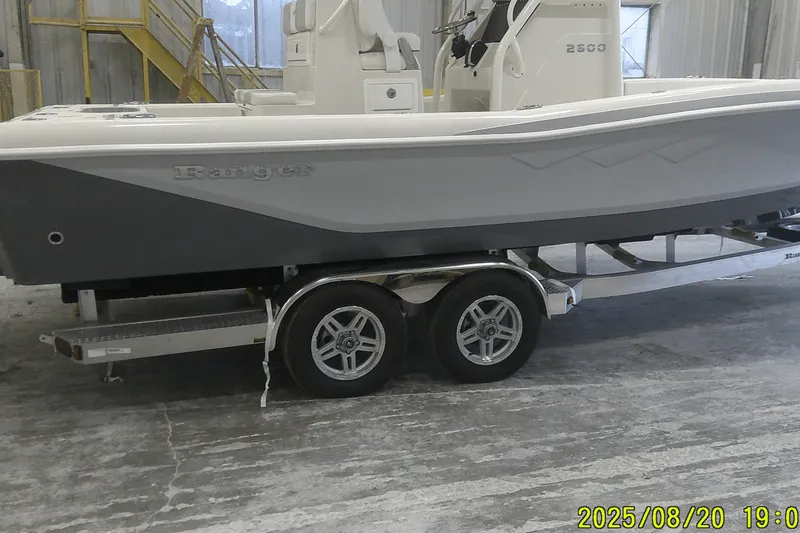 Slide: The Image of 2024 Ranger 2600 Bay boat on trailer in warehouse setting. - 7