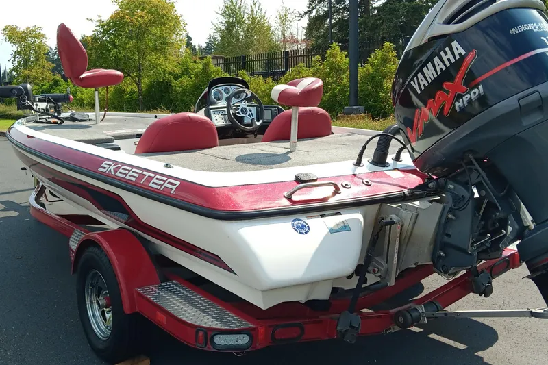 Slide: The Image of 2009 Skeeter ZX190 boat with Yamaha engine, red and white design, parked outdoors. - 10