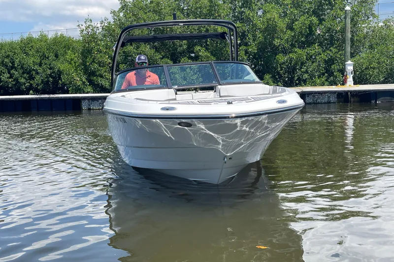 Slide: The Image of 2021 Monterey M225 boat on calm water near a dock, surrounded by greenery. - 10