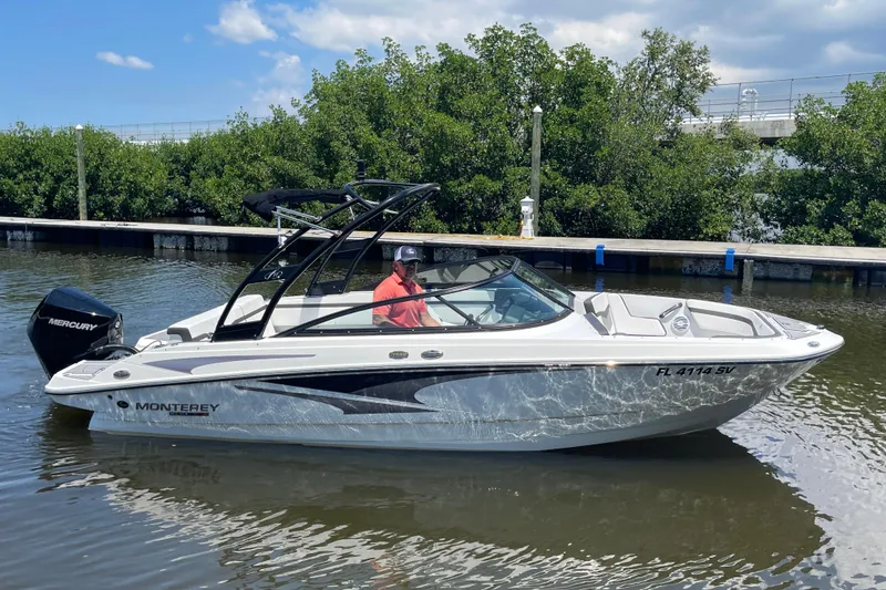 Slide: The Image of 2021 Monterey M225 boat on water, featuring sleek design and Mercury engine. - 17